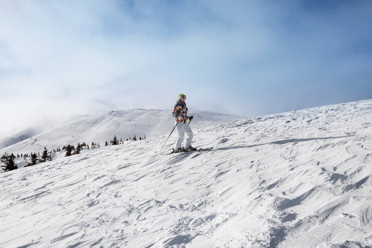 Woman skiing on piste at snowy resort. Winter vacation