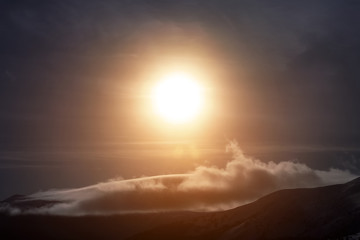 Beautiful landscape with foggy mountains in wintertime on sunny morning