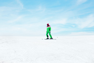 Naklejka na ściany i meble Sportsman skiing on piste at snowy resort. Winter vacation