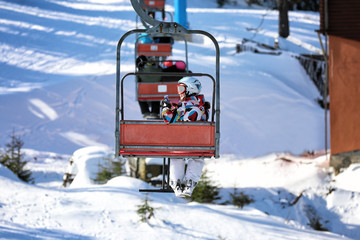 Woman on ski lift at snowy resort. Winter vacation