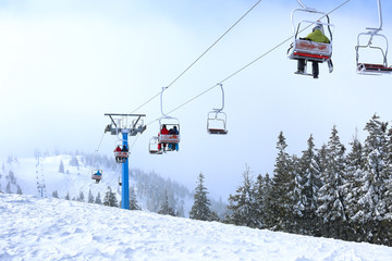 Fototapeta na wymiar Ski lift at mountain resort. Winter vacation
