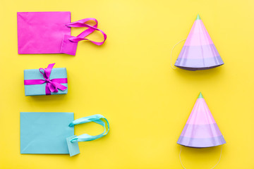 Gift box and colorful paper bag on yellow background top view space for text