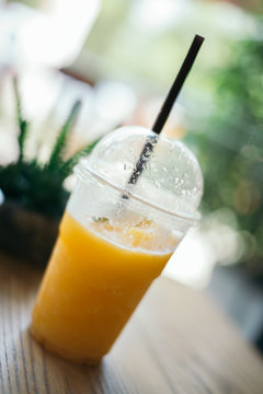 Orange juice smoothie glass on wood table