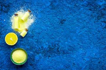 Fototapeta na wymiar Natural citrus cosmetics. Spa salt near lemon on blue background top view mock-up