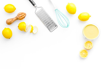 Fototapeta na wymiar Cook lemon curd. Sweet cream in bowl, fruits, kitchen utensils on white background top view copy space