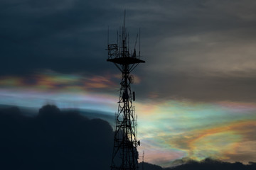 Silhouette of cellular tower with beautiful sunset cloudy sky