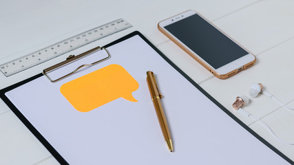Top view of the designer's workplace with smartphone, tablet, headphones and pen.