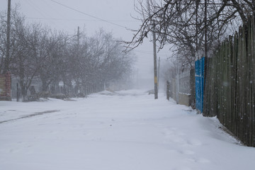 A snowy village street during a snow storm