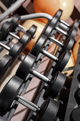 Naklejka premium Closeup of modern gym interior with dumbbell equipment for weightlifting