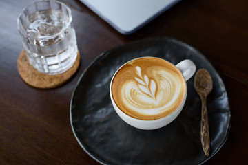 Latte art hot coffee on the table at coffee shop.