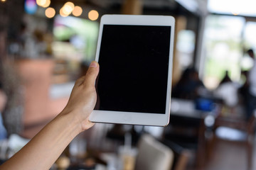 Woman hand holding tablet at cafe'