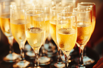 cold champagne on the tray. Sparkling wine poured by the glass.