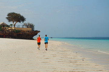 Two athletes make morning running on the beach