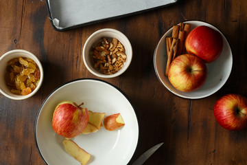 Ingredients for cooking of stuffing for apple strudel, top view. Apples, raisins and cinnamon on wooden table