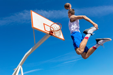 Young Basketball street player making slam dunk - obrazy, fototapety, plakaty