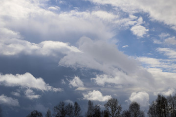 Spring. blue sky with fluffy white clouds. sun, sunlight, clouds, sky - spring changeable weather.