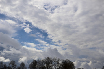Spring. blue sky with fluffy white clouds. sun, sunlight, clouds, sky - spring changeable weather.