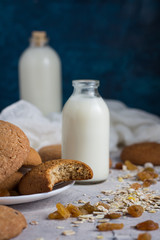 Healthy Breakfast with Oatmeal Cookies, Raisins, Oatmeal and Milk on a Dark Blue Background. Concept Healthy Eating