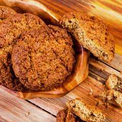 Sweet appetizing homemade oatmeal cookies in wooden plate. Selective focus. Square.