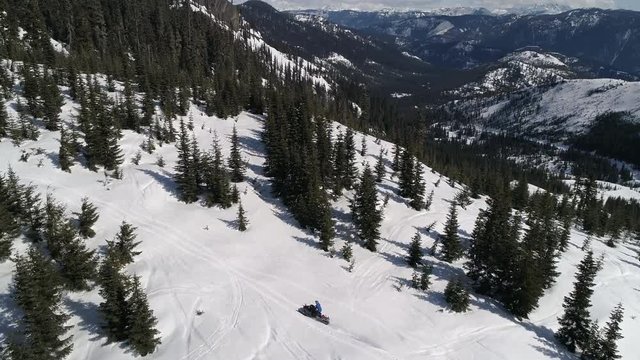 Man Riding Snowmobile on Scenic Mountain Ridge