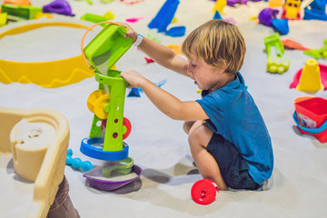 Boy playing with sand in preschool. The development of fine motor concept. Creativity Game concept © galitskaya