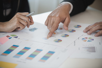 Hand of Business man and Business woman working on Data Charts,document  at office desk. analyzing brainstorming, meeting concept..