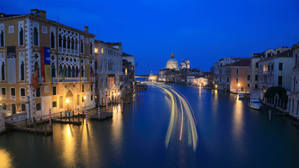 Obraz premium Gliding Into the Night of Beautiful Venezia ~ Evening scenery of Venice with light trails of boats & ferries on Grand Canal and Basilica di Santa Maria della Salute in the distant background