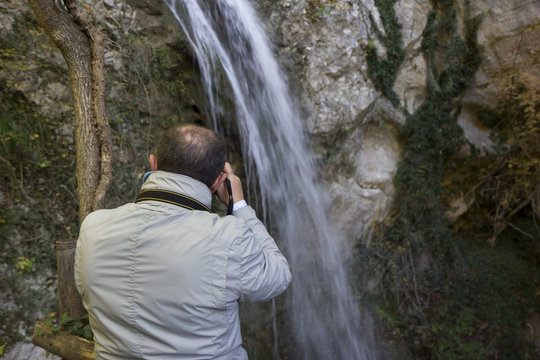 hiker take photo of waterfall