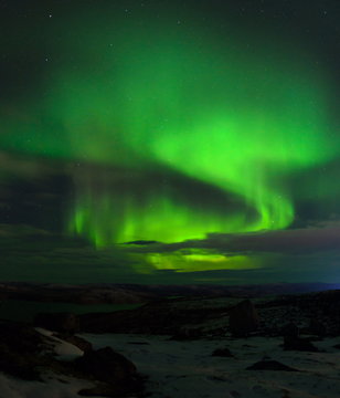 Northern Lights, polar lights above the hills and tundra bay in winter.