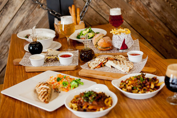 covered table with salad with soup with wine and beer with burger