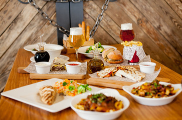 covered table with salad with soup with wine and beer with burger