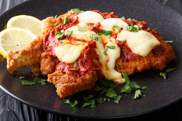 Milanesa a la napolitana Beef cutlet breaded with mozzarella cheese and tomato sauce closeup....