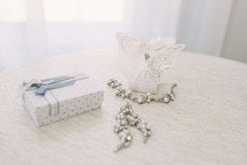 Fototapeta na wymiar Women's wedding jewelry (earrings, bracelets) on a light background, selective focus