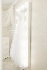 wedding dress hanging on the mirror, bride's morning