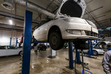 cars in garage with special equipment prepared for repair