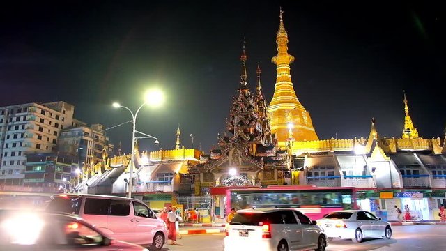 YANGON, MYANMAR - FEBRUARY 14, 2018: The heavy traffic at the bright golden stupa of Sule Pagoda, located in Downtown, on February 14 in Yangon.