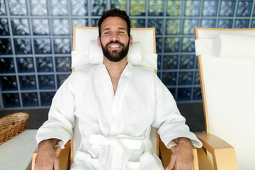 Handsome man relaxing in chair at spa center