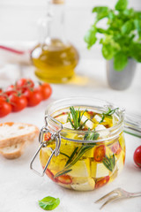 marinated feta cheese with olive oil, spicy herbs, garlic and chili pepper in jar