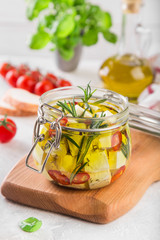 marinated feta cheese with olive oil, spicy herbs, garlic and chili pepper in jar