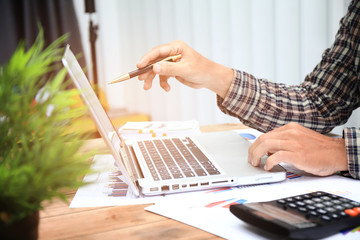 Businessman pen pointing graph chart for analyzing investment in his office