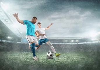 Poster Soccer player on a football field in dynamic action at summer da © Andrii IURLOV