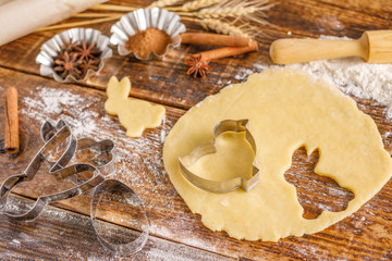 Dough and culinary forms for baking cookies of different types. Still-life on a wooden background.