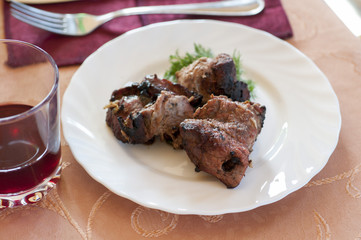 Pieces of grilled pork on plate with salad