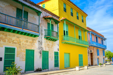 Fototapeta na wymiar bright, saturated fosada houses in Cuban cities, on a bright sunny day