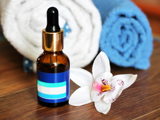 Hyaluronic acid in a bottle with pipette, towel and Orchid