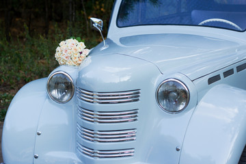 wedding bouquet lies on an old beautiful car