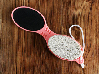 Pink pumice for female feet on wooden background