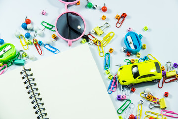 Top view of laptop, blank notebook, paper clips  and smart phone with white background and copy space.