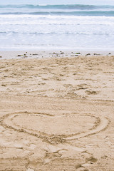 heart on the sand by the sea in summer