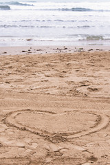 heart on the sand by the sea in summer